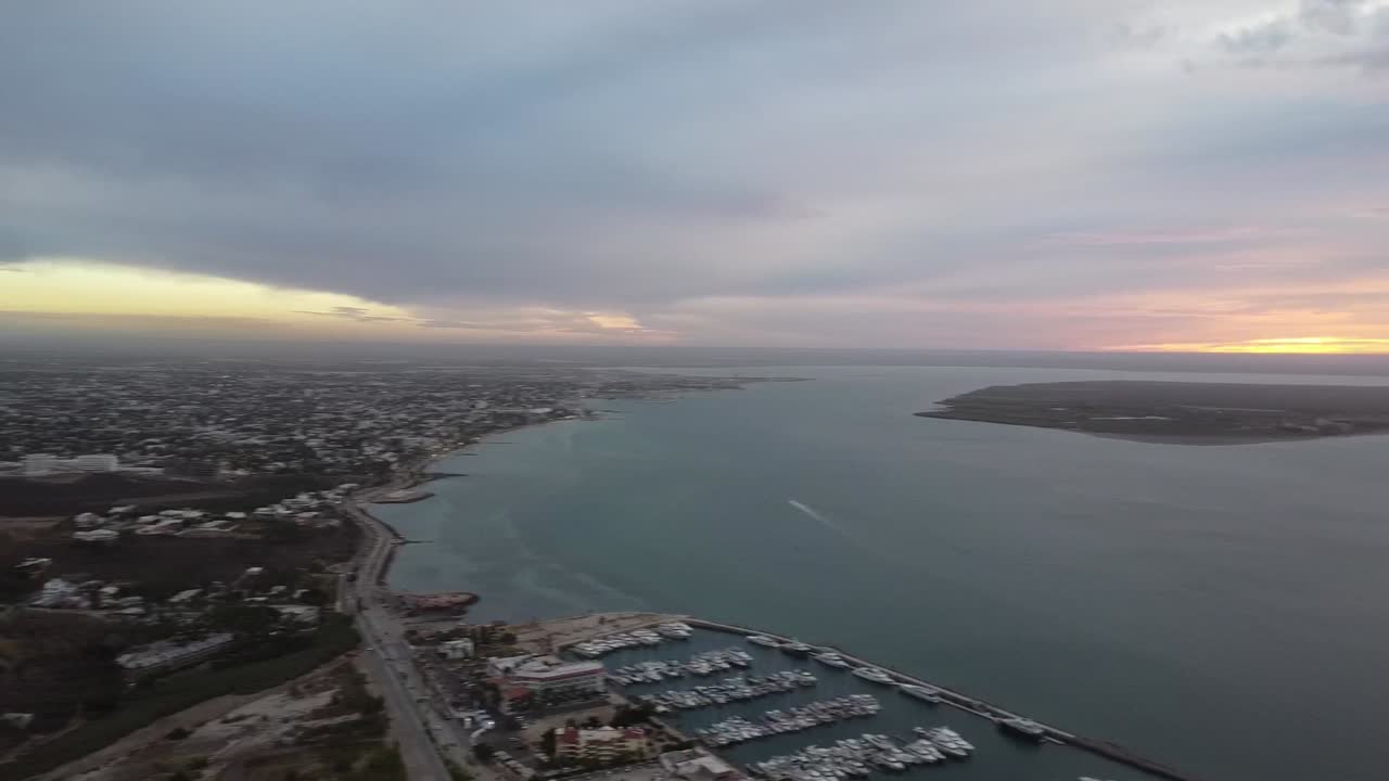 vista costera de la paz, baja california al anochecer con cerro calavera, cielos nublados, toma aérea
