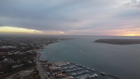 Coastal-view-of-La-Paz,-Baja-California-at-dusk-with-Cerro-Calavera,-cloudy-skies,-aerial-shot