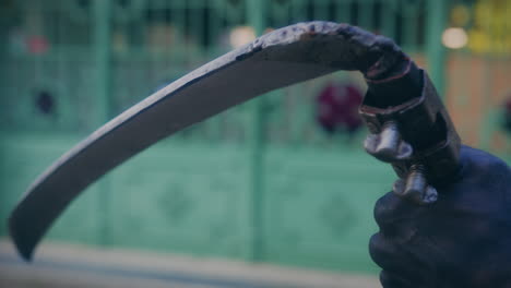 hombre disfrazado de segador sosteniendo la guadaña de cerca