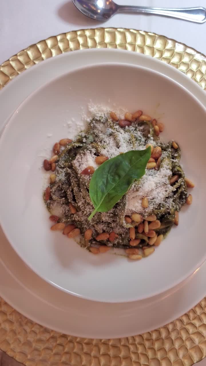 Elegant top-down shot of a pesto pasta dish with pine nuts and basil