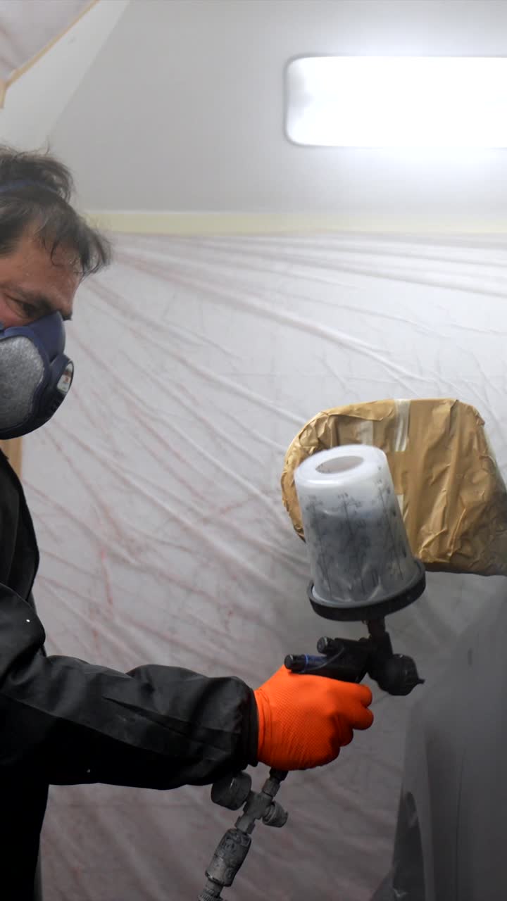 Man in Respirator Mask Spray Painting a Car