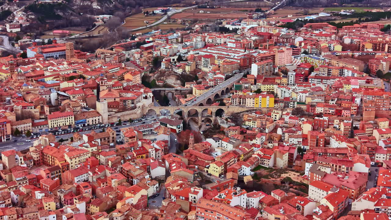 Scorci di una città con tetti rossi, ponti e colline sullo sfondo, di giorno, in Spagna