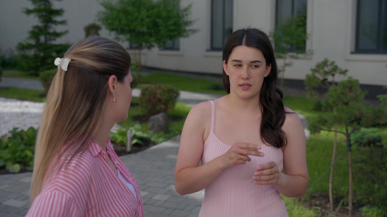 Two Young Women Having a Conversation Outdoors
