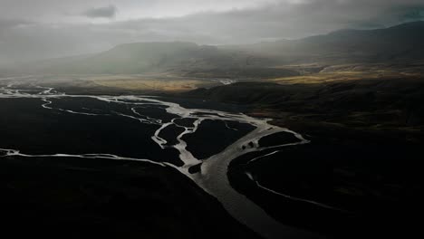 aerial thor valley, glacial river flowing through black volcanic floodplain, thorsmörk dramatic moody landscape iceland