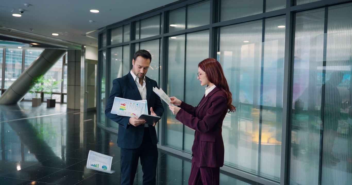 Angry female boss storms toward male employee and tosses architectural design documents at him in dramatic slow motion confrontation in modern corporate office lobby