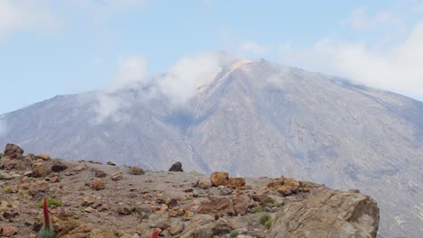 Majestic-volcano-Teide-towering-behind-rock-in-Tenerife-national-park,-tilt-up