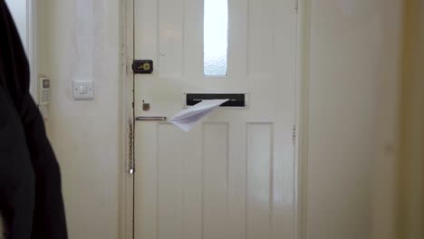 mail letter being delivered through a door mounted letterbox, mailbox opening