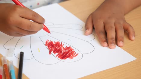 child coloring a flower