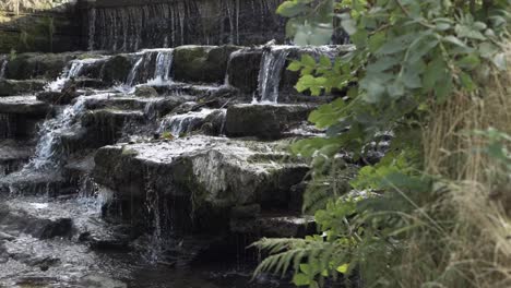 water flowing over cascading waterfall medium panning shot