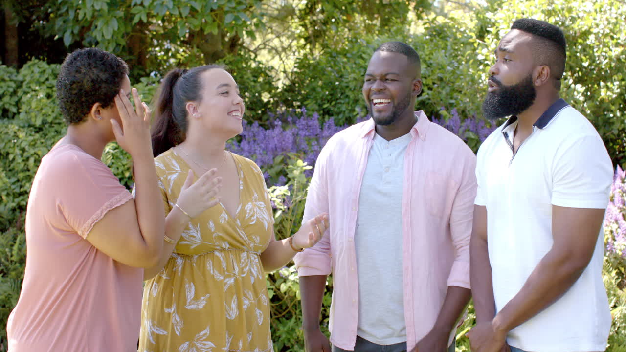 Laughing and chatting, group of diverse friends enjoying outdoor gathering in garden