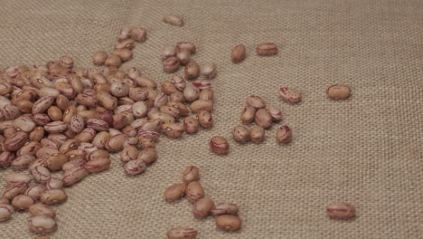 Dry-red-beans-Borlotti-rotating-on-jute-background,-typical-Mediterranean-vegan-vegetarian-diet-food,-protein-healthy-source