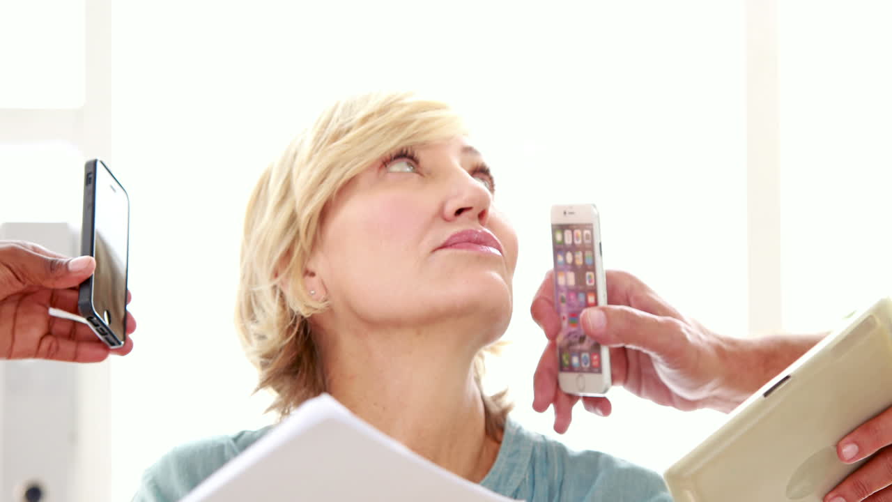 mujer estresada acosada por los teléfonos inteligentes