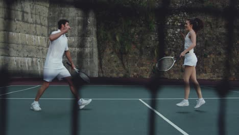 woman and man playing tennis on a court