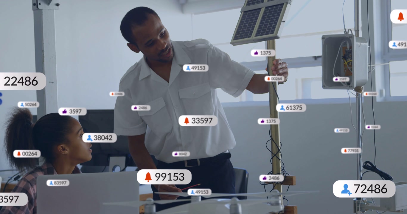 Mentor leaning, pointing at solar panel while student watching laptop overlays appearing education