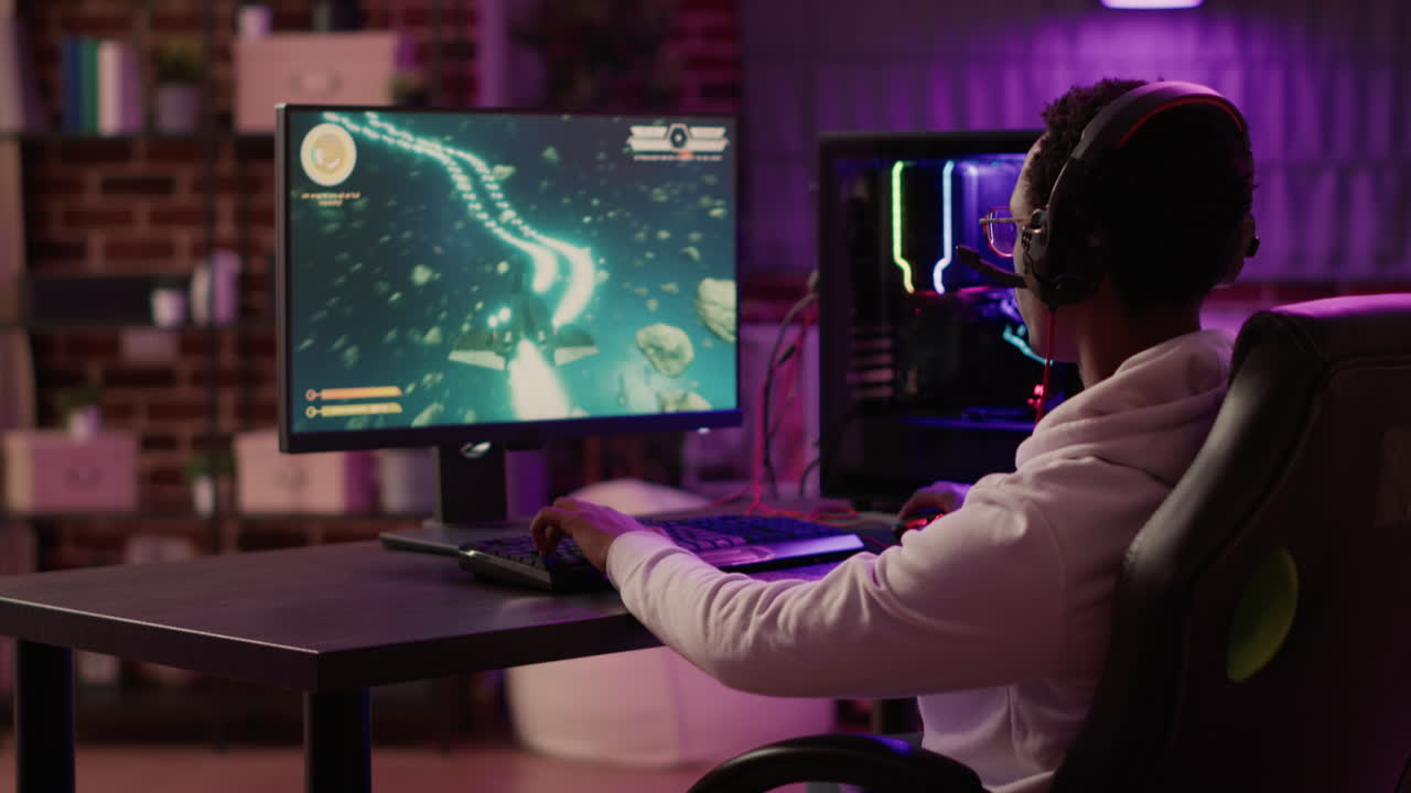 Handheld shot of gamer feeling happy celebrating after winning competition in online space shooter on gaming pc