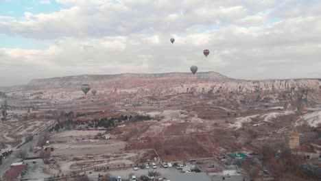 aerial 4k drone footage of hot air balloons over the desert landscape of cappadocia, turkey