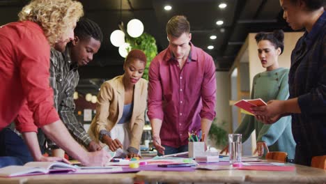 Happy-diverse-business-people-discussing-work-during-meeting-at-office