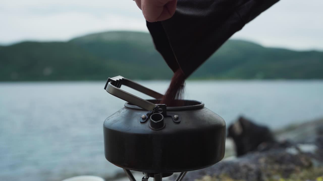 verter café molido en una tetera de agua portátil y agitar con cuchara