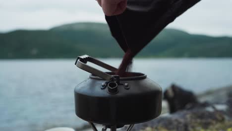 Pouring Ground Coffee Into Portable Coffee Pot Water Kettle And Stir With Spoon