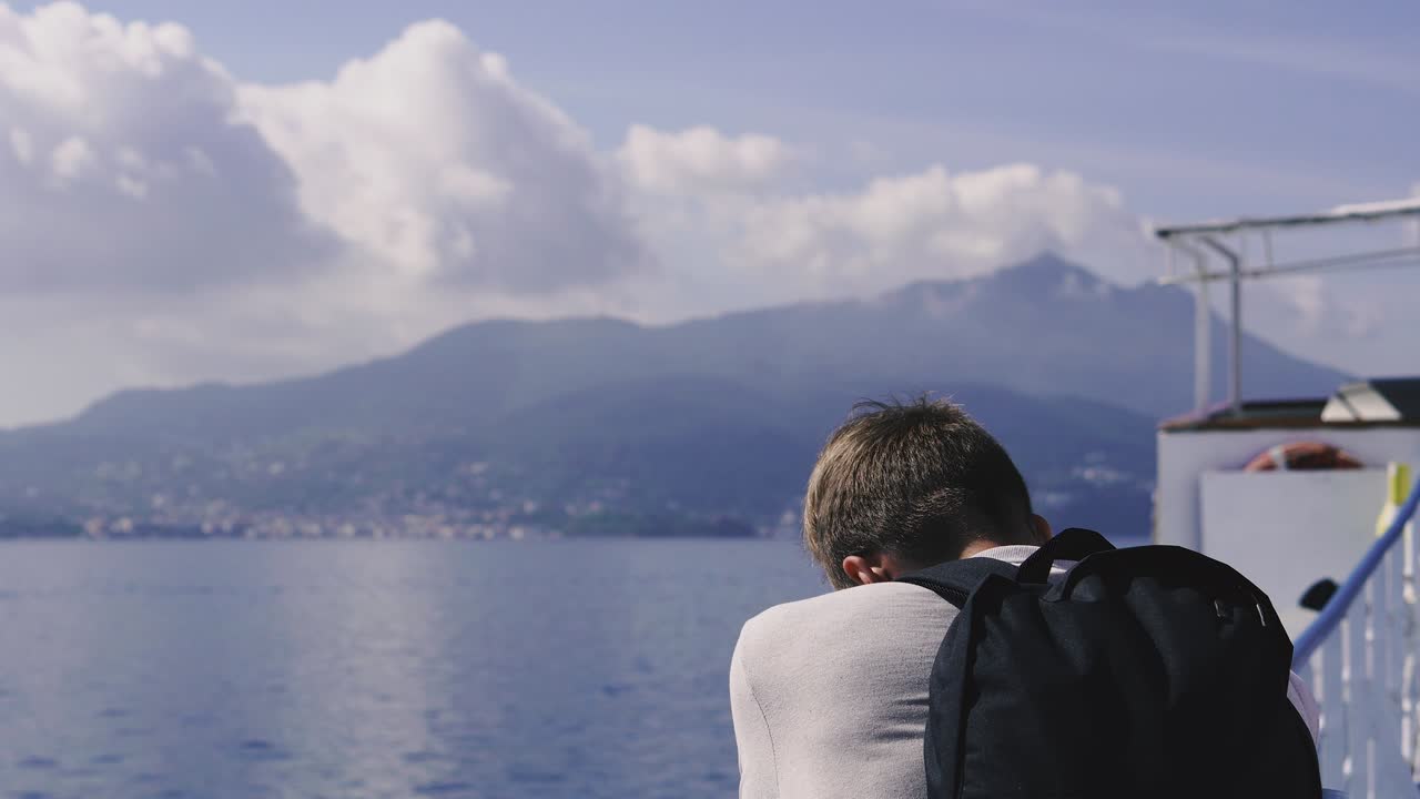 Journey. The guy is sailing on a ferry boat and listening to music through headphones.
