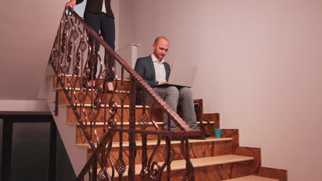 company manager using laptop overworking on stairs