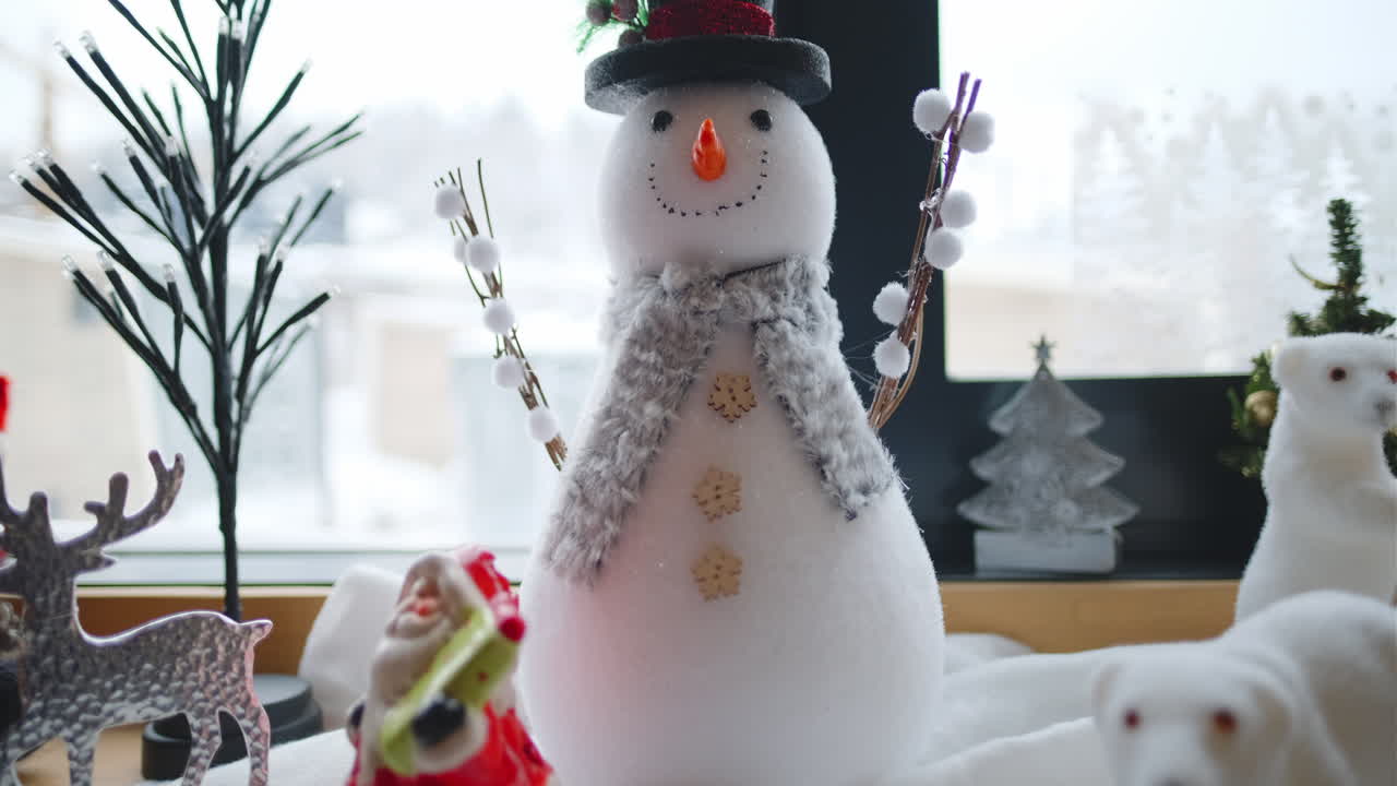 Christmas decorations with a snowman, santa claus, reindeer, and polar bears on a windowsill