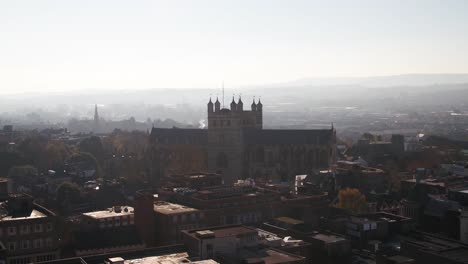 exeter, uk. a hazy horizon with exeter cathedral appearing as a holy silhouette amongst the urban environment