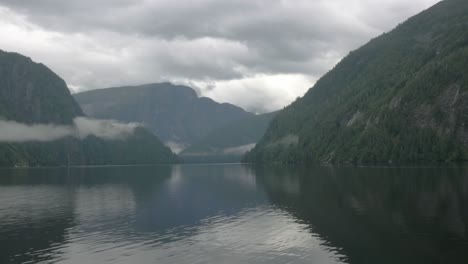 Eine-Tiefenaufnahme-Der-Nebligen-Berge-Alaskas,-Die-Auf-Dem-Wasser-In-Einem-Fjord-Ruhen