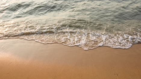 ocean waves crash on the sandy beach in pattaya, thailand