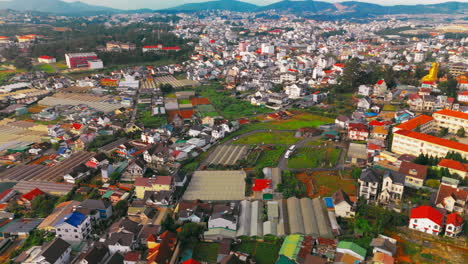 aerial view of the countryside surrounding da lat city. the footage showcases rolling hills, lush green fields, and colorful flower farms, highlighting the region's natural beauty and agriculture.