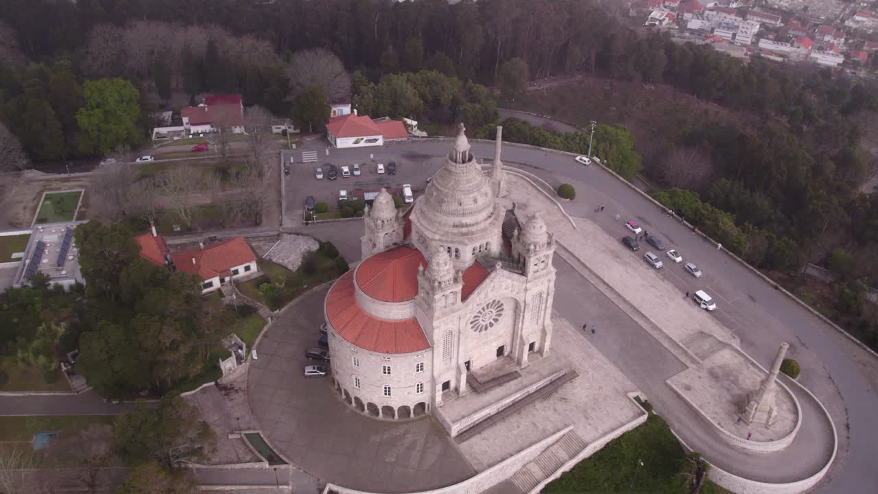 círculo alrededor de la iglesia de viana do castelo en portugal en la cima de una colina boscosa, aérea