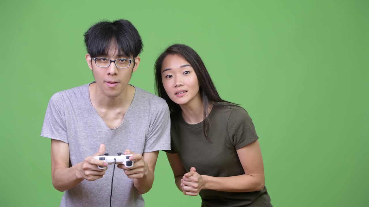 Young Asian couple playing games together