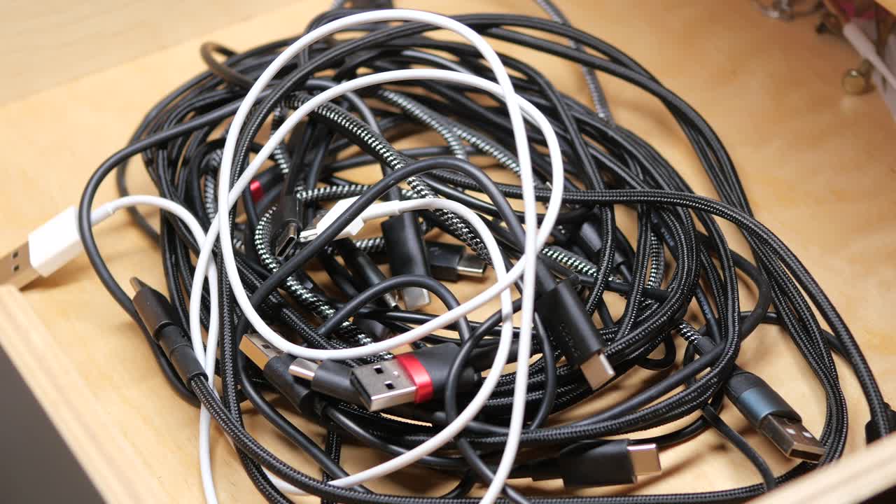 Tangled USB Cables and Connectors in a Wooden Drawer