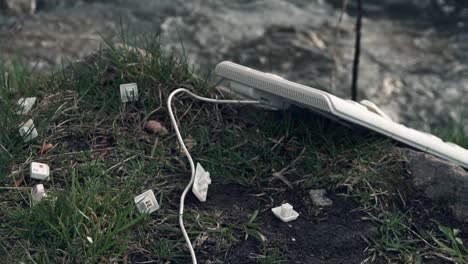 discarded computer keyboard and parts in nature