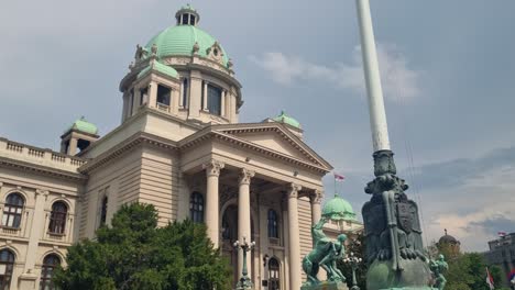 revealing shot of the entrance and green domes of the serbian national assembly (skupština) in central belgrade, captured on a cloudy spring day