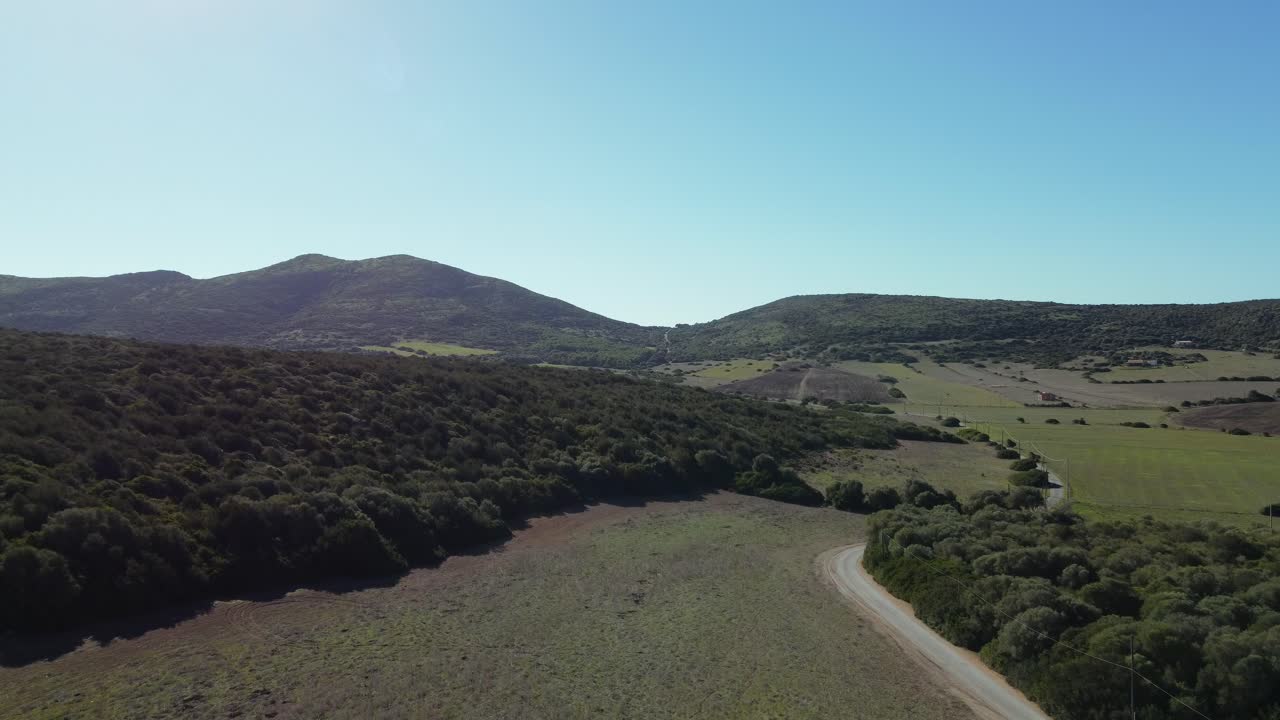 Green countryside landscape field and hills in Sardinia island, aerial, dolly in