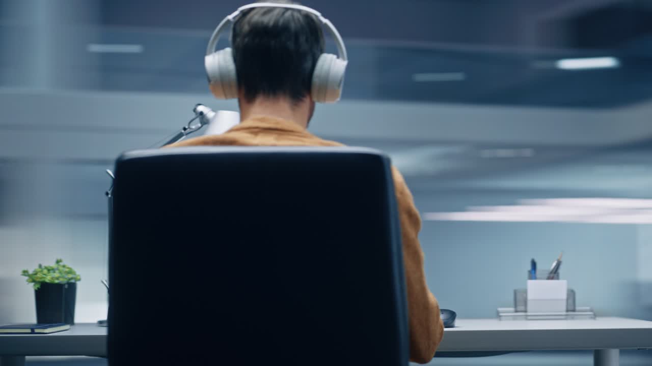 360도 현대 사무실: 노트북 컴퓨터에서 일하는 책상에 앉아있는 백인 사업가, 헤드폰을 착용한 남자, 음악, 캐스트를 듣고, 활기차고 빠른 추적, 카메라를 움직입니다.