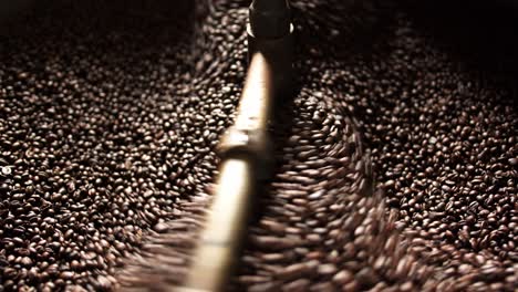 Close-up-of-coffee-beans-being-cooled-down-in-roaster-with-soft-light-coming-in-from-one-side