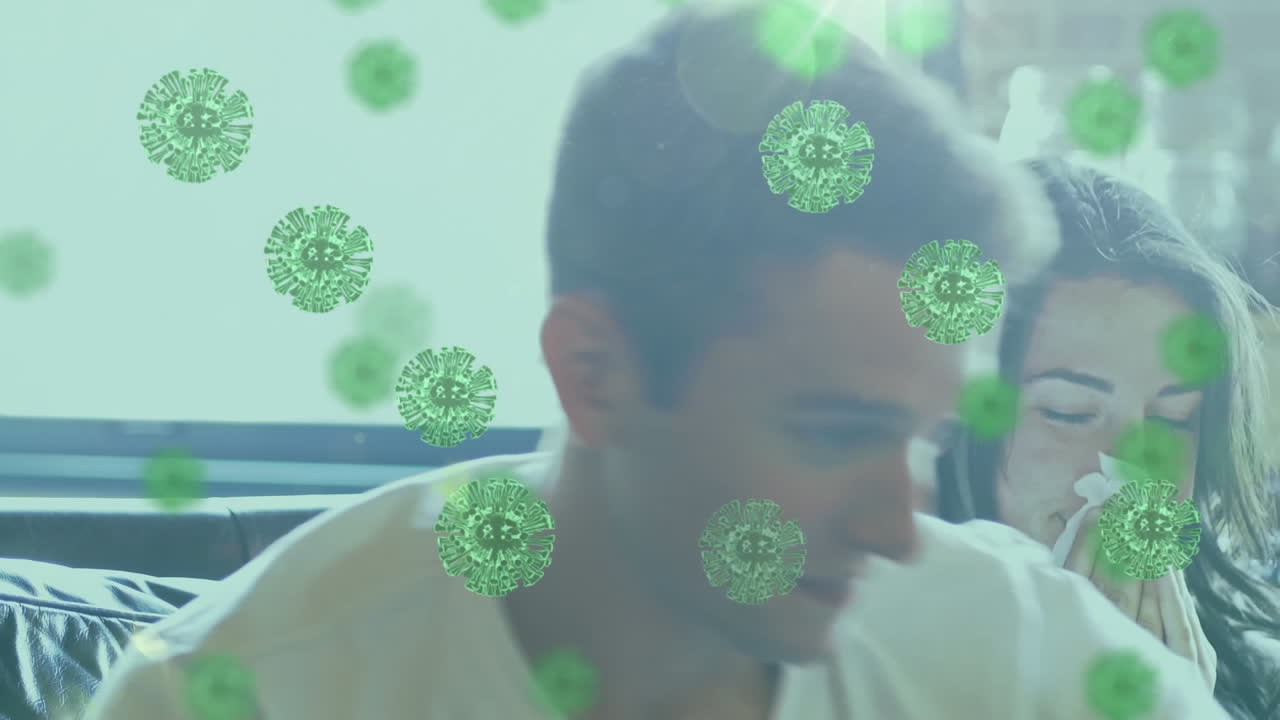 animación de células macro covid-19 sobre una pareja caucásica sentada en el sofá y soplando la nariz