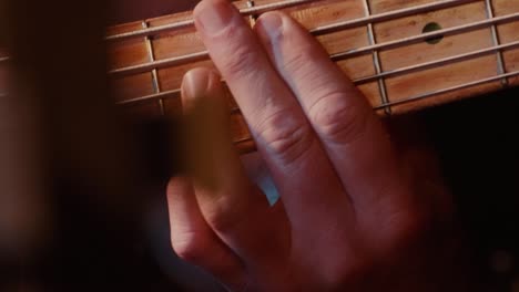 Close-up-of-a-hand-of-a-guitarist-making-chords-while-playing-a-song,-artist-practicing-his-music-style