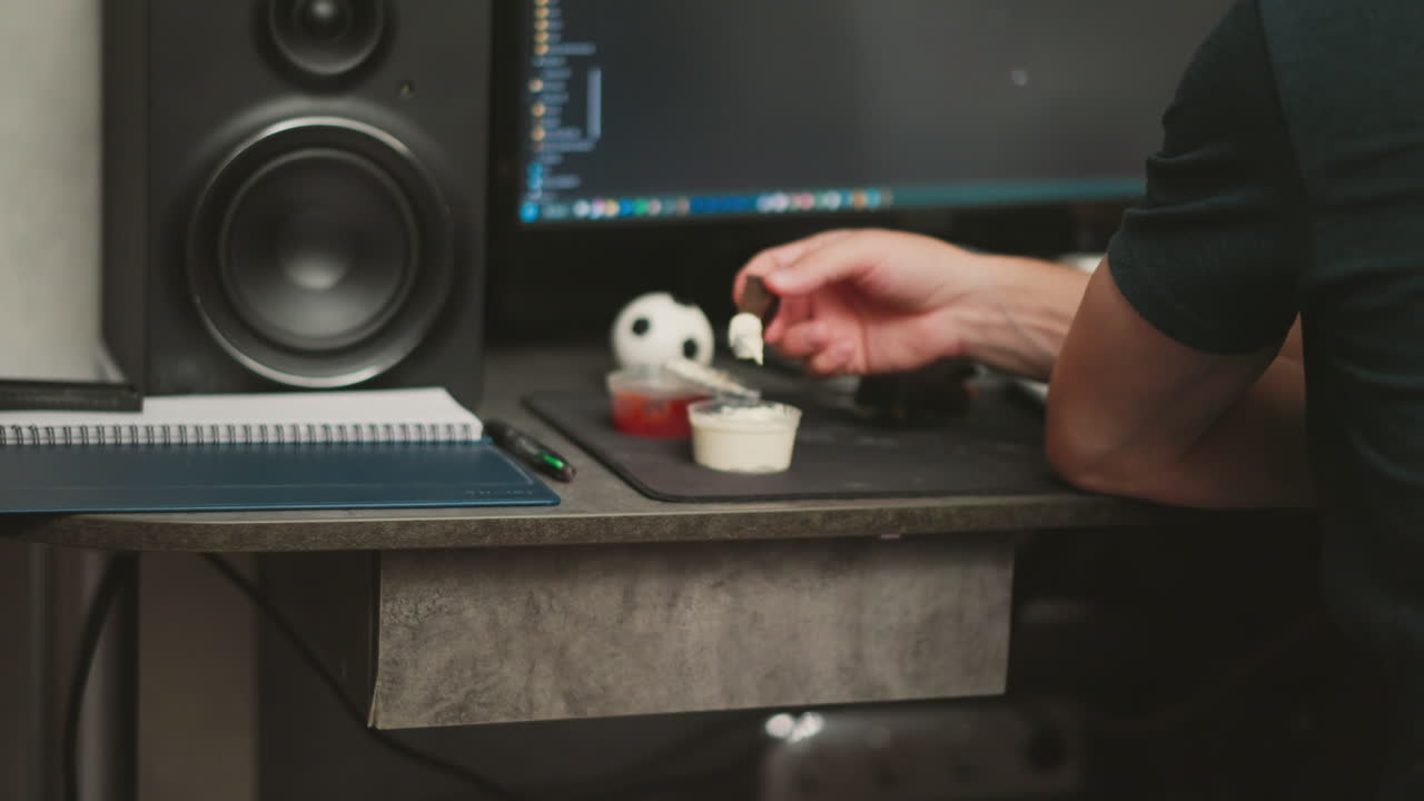 Person Eating a Snack at a Computer Workstation