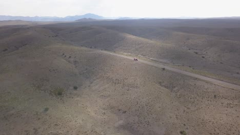 Drone-—-lone-highway-cutting-through-the-West-Texas-mountains-with-truck-passing-through