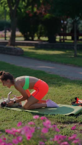 woman exercising with dog in park