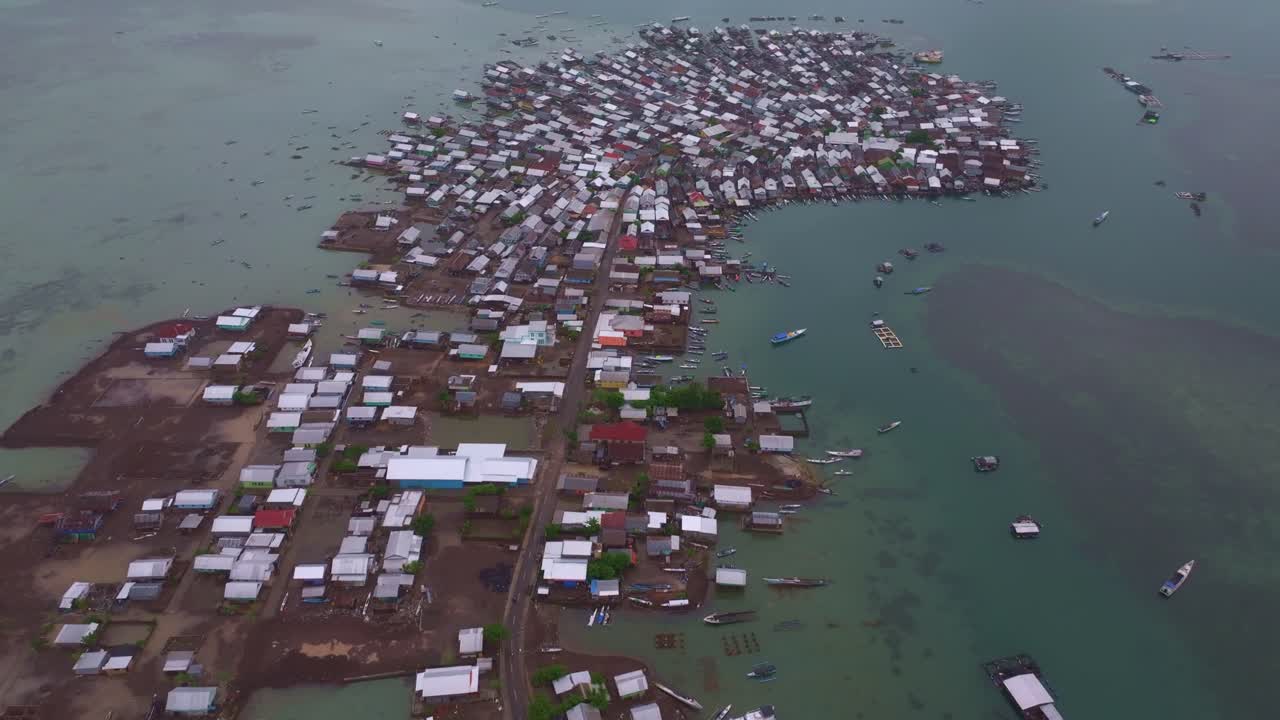 Barcos de pesca aglomeram casas à beira-mar, Ilha Bungin, Indonésia