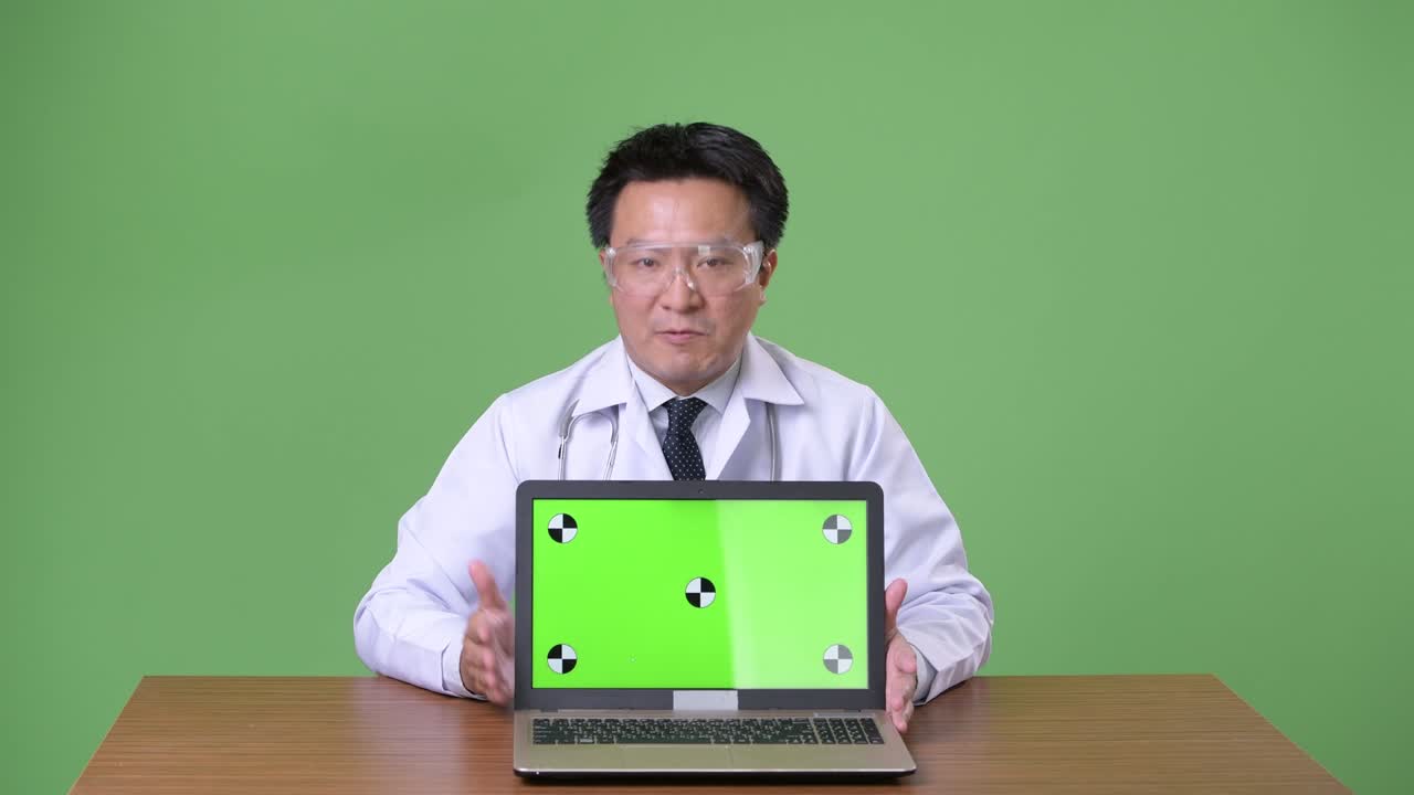 성숙한 일본인 남성, 초록색 배경의 의사