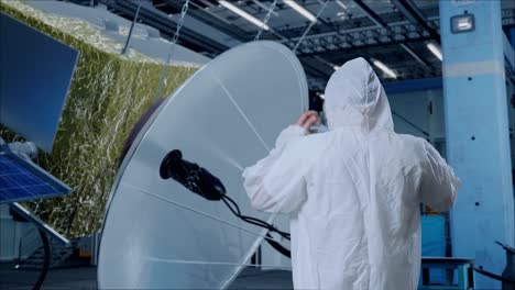 back view of asian male scientist having a headache while standing with spacecraft construction