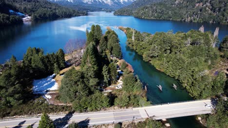 pillars of old bridge and new one with driving cars near lake in argentina, aerial view