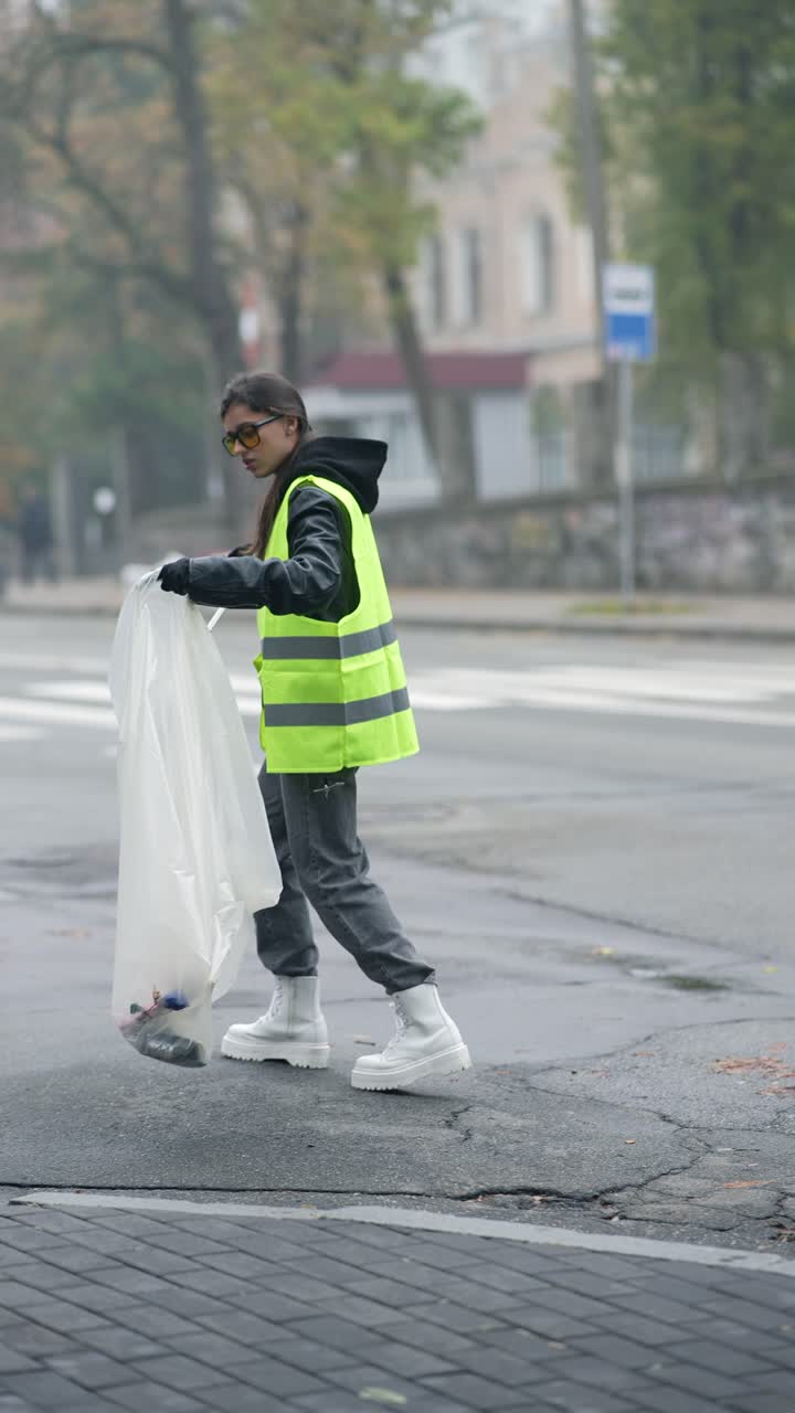 mujer limpiando la basura en la calle de la ciudad