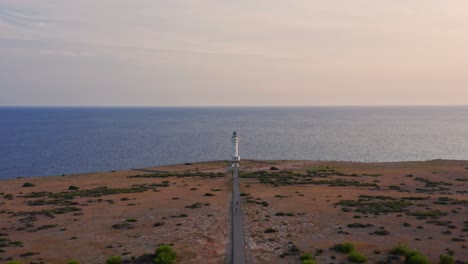 cúpula de faro, camino vacío en llanura seca y mar azul tranquilo