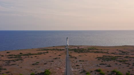 lighthouse cupola dolly in, empty road in dry plain and calm blue sea